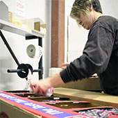 Female packaging and assembling warehouse employee packing a retail box