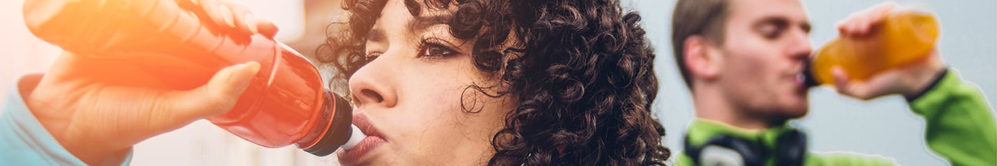 Woman and man drinking colorful sports drinks