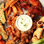 Appetizer plat with wings, french fries, onion boom, and dip