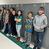 Kids standing in front of lockers in school hallway