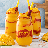 Three frozen gold-colored drinks in mason jars with Dot logo made using Tajin
