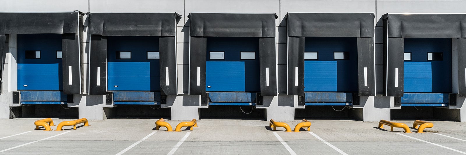 A truck loading dock bay with five blue docks