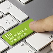 Person using their pointer finger to press a green button on a laptop that reads "EDI Electronic Data Interchange"