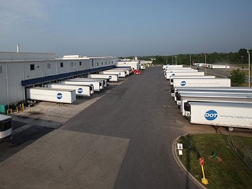A Dot Foods distribution center's truck lot, with DTI trucks in two rows to the left and right