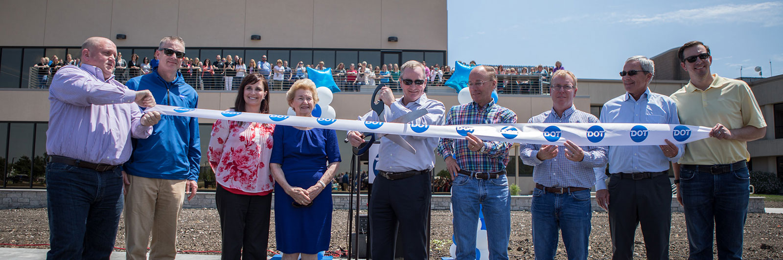 Dot Foods senior leaders and co-founder Dorothy Tracy holding a ribbon as part of grand opening ceremony for Dot Foods Mt. Sterling's office expansion.