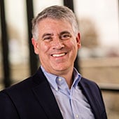 Dot Foods Chief Information Officer Brian LeDuc standing in front of windows at Dot Foods Mt. Sterling