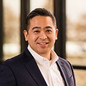 Vice President of Legal Mart Truong in front of windows at Dot Foods Mt. Sterling