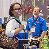 Female trade show attendee speaking to male trade show exhibitor