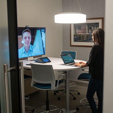 Female office employee standing at a desk while on a Zoom conference call